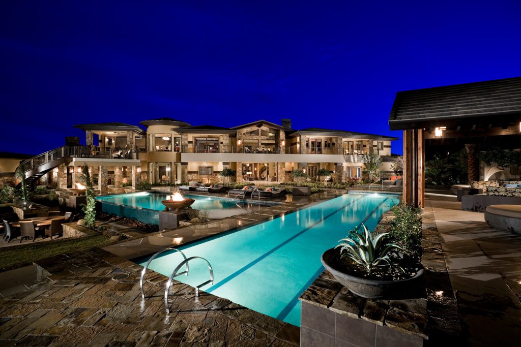Custom home pool, fire features and patio at dusk